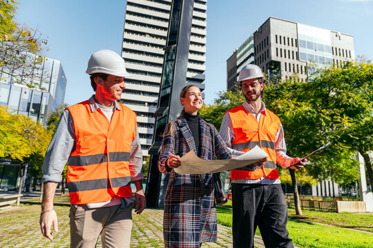 Business team in city discussing construction plan outdoors