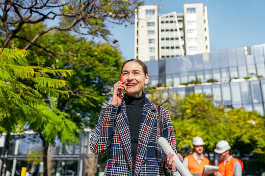 Businesswoman on phone outside modern office building