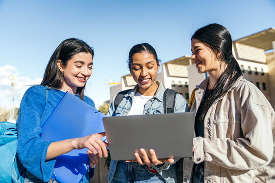 University students collaborating with laptop on campus