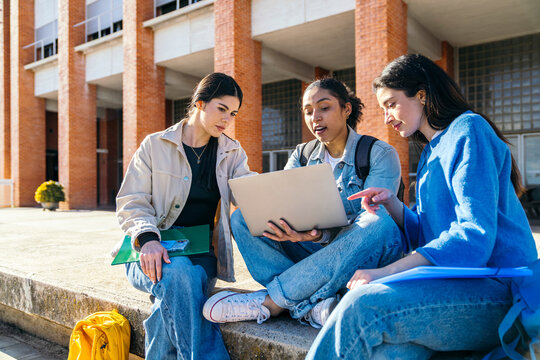 University student group study with laptop on campus steps