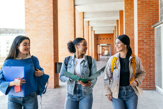 University students walking on campus corridor, chatting
