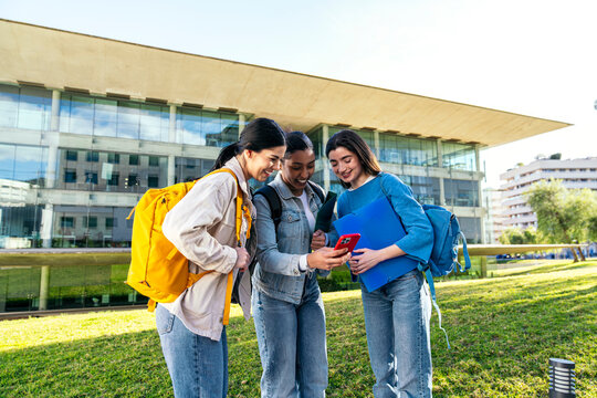 University students using smartphone outside campus building