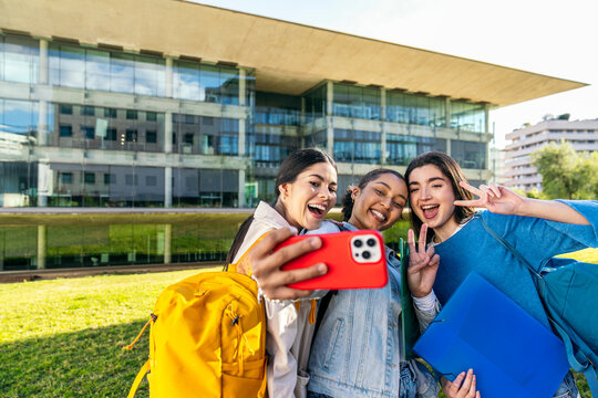 Students take smartphone selfie outside university campus
