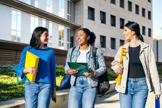 Students walking and talking on university campus walkway
