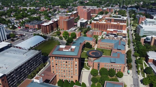 Aerial view of modern university campus featuring brick residential halls and academic buildings on a sunny summer day.