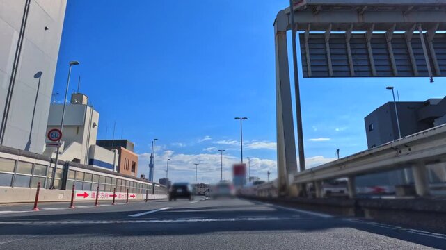 首都高速道路から望む高層ビル群と眩しい太陽の風景