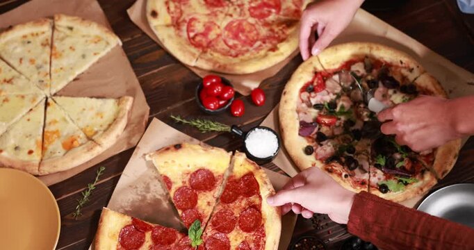 People eating yummy pizzas at wooden table indoors, above view