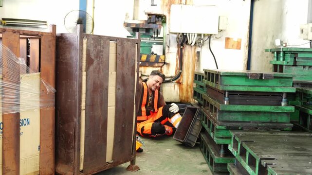 Team of professionals in protective equipment working together in a warehouse filled with stacked wooden pallets