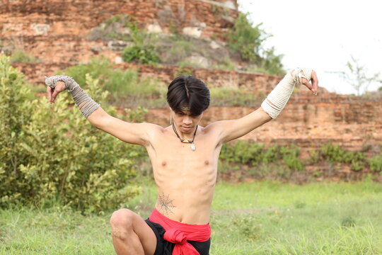 Thai Boxer Performing Traditional Wai Kru Ritual at Ancient Temple Site