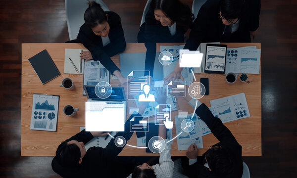 A diverse team engages in a professional meeting, collaborating on data analysis and strategy development using technology and modern office resources. Trope