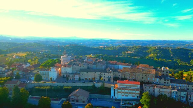 Pristine aerial truck left pan right shot from Monte Rinaldo, a complete overview of the town with its buildings, roads, cars, walls, trees, arches, sumptuous Marche hillscapes lying in the background