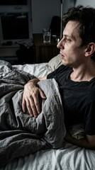 Fototapeta premium Troubled Man Awakes In Bed Reflecting On Sleepless Night Worries