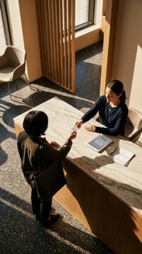Professional Receptionist Greeting Guest At Modern Hotel Lobby Desk With Natural Light