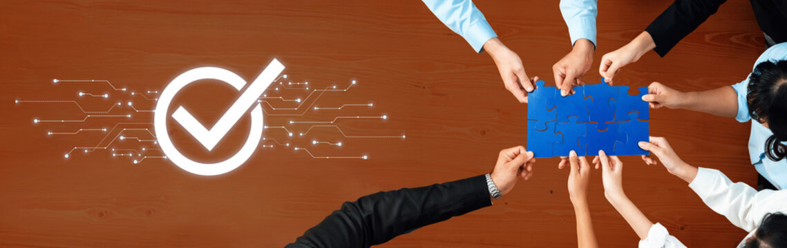 Diverse hands work together to fit a blue puzzle piece, symbolizing teamwork and successful collaboration in business, complemented by a digital checkmark. Trope