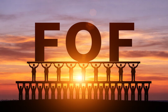 Numerous small figures silhouetted in the morning sun, holding up FOF