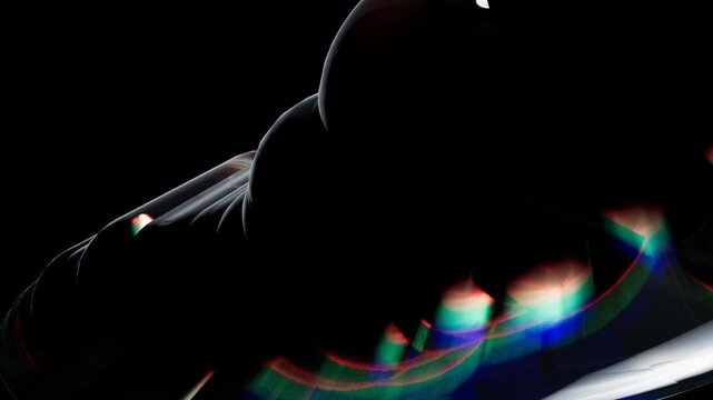 Abstract 3d digital art with smooth glossy black curved shapes and colorful light reflections on a dark background for modern technology design concept