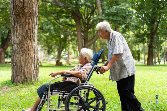 Smiling elderly couple with wheelchair enjoying retirement together, representing senior health insurance, long-term care, financial security, love, support and healthy aging lifestyle.