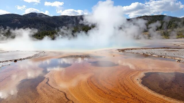 Vibrant Grand Prismatic Spring with colorful microbial mats and rising steam.