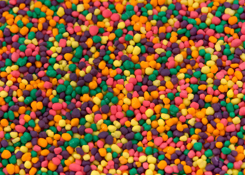 Close up of hundreds of tiny brightly colored candy. Sweet treat background.