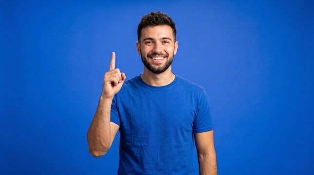A smiling man pointing his index finger upward, presenting an idea or eureka moment against a vibrant blue background.
