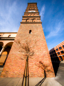 Historic brick clock tower stands tall against a bright blue sky
