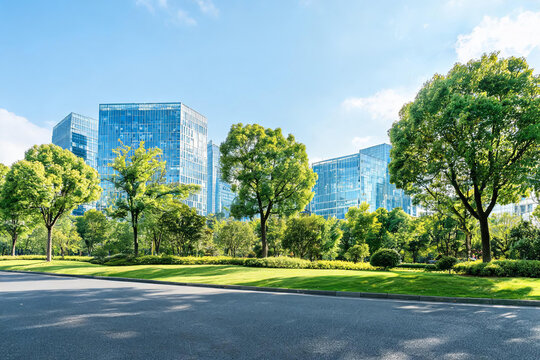 Modern glass office buildings stand beside a well-maintained urban park with green lawns and trees under a clear blue sky.
