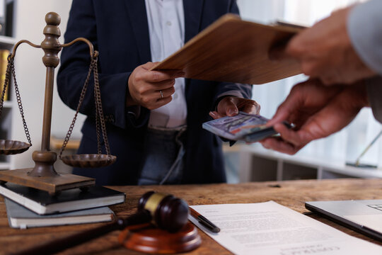 Person accepting a large sum of cash from another individual, symbolizing illicit payments, corruption, bribery, and financial fraud undermining legal justice and business ethics