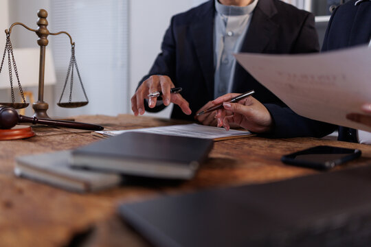 Legal professionals discussing contract documents in a law firm office, analyzing clauses and providing consultation, symbolizing justice, legal advice, and agreement negotiation