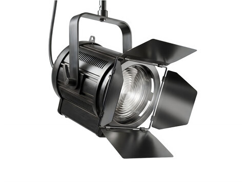 Black fresnel studio spotlight with barn doors and bright light beams for cinema stage and film production equipment.
