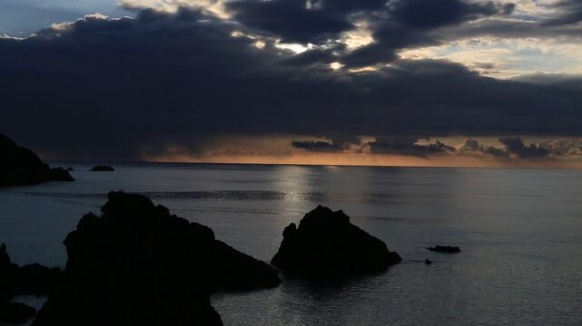 奄美大島の夏の夕日 黄金色に染まる海とリーフの海岸風景