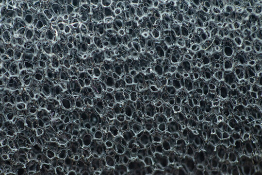 Close-up of porous black sponge texture for background or design
