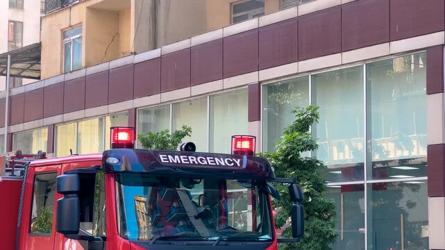 The cabin of Georgian red fire truck, fire engine on the street. Red signal lights on the vehicle are flashing. Emergency, urban, transport, accident and firefighting concept