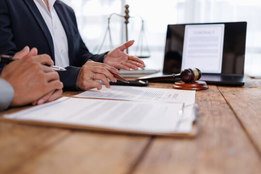 Legal professional discussing contract terms and offering advice to client in office, focusing on law, justice, and agreement, with gavel and scales symbolizing authority and arbitration
