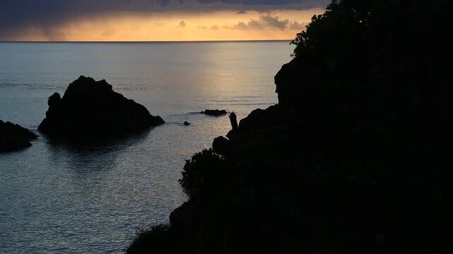 奄美大島の夏の夕日 黄金色に染まる海とリーフの海岸風景