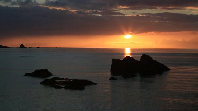 奄美大島の夏の夕日 黄金色に染まる海とリーフの海岸風景