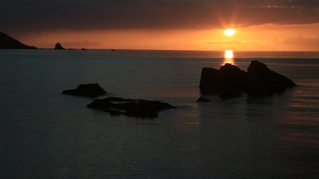 奄美大島の夏の夕日 黄金色に染まる海とリーフの海岸風景