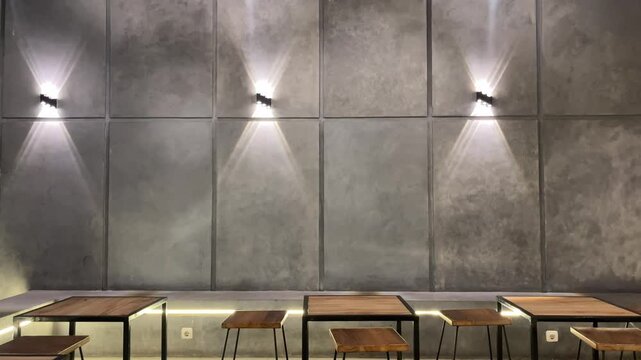 Side view of wooden tables And chairs, grey cement tables and chairs. outdoor seating for restaurant, Cafe or coffee shop. wall, lamps, lights. white, bright. grey, gray, cement. copy space, empty