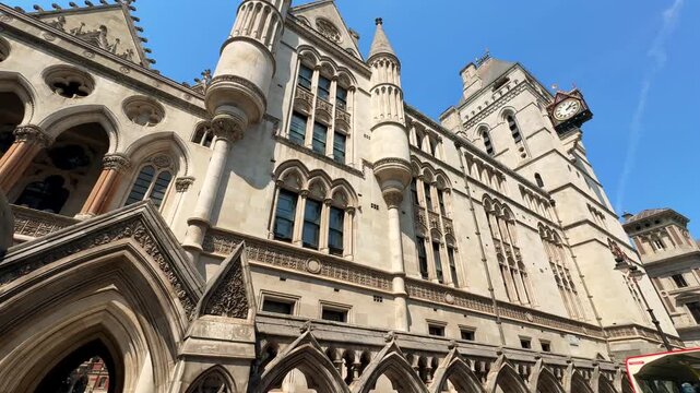 A stone courthouse features ornate arches, decorative towers and a clock