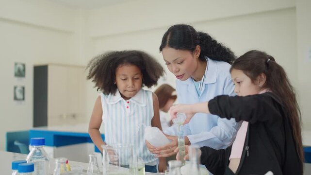 Young students girls in a lab setting. They wear lab coats and focus on experiments. Teacher guides them with hands-on support. Curious expressions show engaged learning. Ideal for education, science