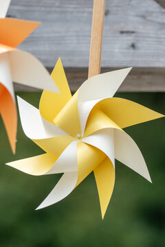 Yellow and White Paper Pinwheel on a Wooden Stick Outdoors