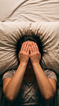 Top-Down Shot of Person in Regret, Dimly Lit Bedroom Scene