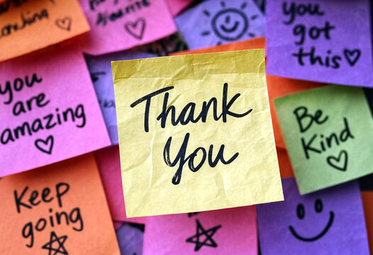 Colorful motivational sticky notes with thank you and positive messages arranged together creatively