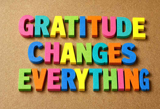 Colorful wooden letters spelling gratitude changes everything on a textured background for inspiration