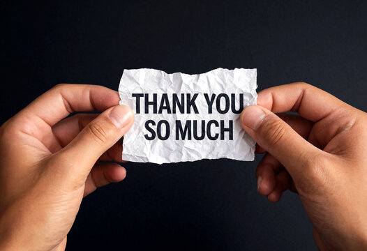 Gratitude message with thank you so much written on crumpled paper held by hands