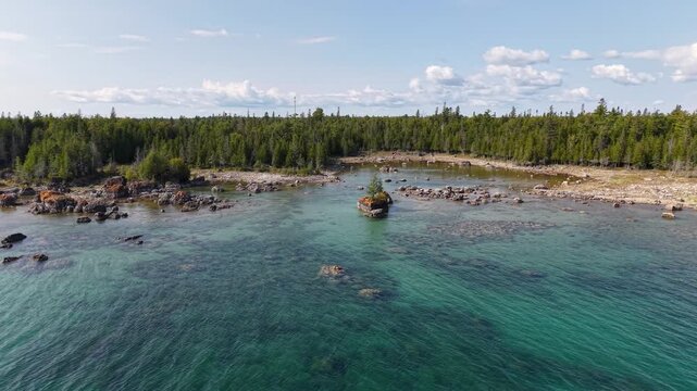 Aerial view of turquoise water and limestone rock formations along scenic coastline during summer day.