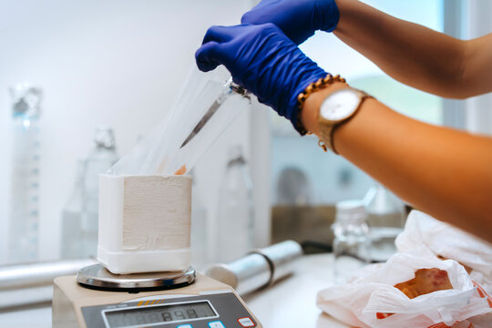 Laboratory Technician Weighing Sample On Digital Scale With Gloved Hands In Clean Lab