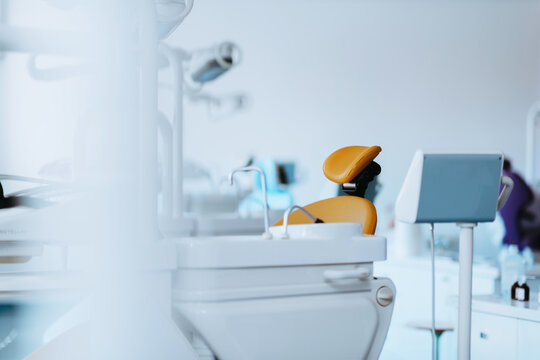 Modern Dental Clinic Interior With Yellow Dental Chair And Treatment Equipment In Bright Setting