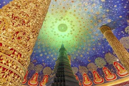 In the emerald green silence of Wat Paknam Phasi Charoen, the glass chedi rises like a glowing heart of light. Golden pillars support a cosmic ceiling that plunges the room into a sense of infinity. The wall paintings tell of Buddha's path to enlightenment and combine earthly beauty with spiritual depth that makes this place so unique, Phasi Charoen district, Thonburi, Bangkok, Thailand
