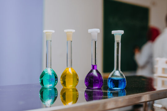 Colorful Chemistry Flasks With Liquid Solutions On Laboratory Bench In Science Classroom Setting
