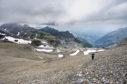 Mountaineers on hiking trail in bare rocky mountain landscape in bad weather, Rote H&auml;rd, Bernese Alps, Bernese Oberland, Switzerland